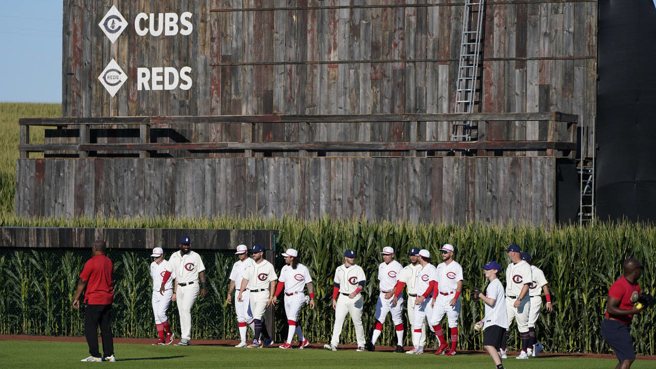 Chicago Cubs and Cincinnati Reds players walk onto the field before a baseball game at the Field of...