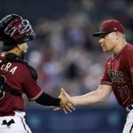 Arizona Diamondbacks relief pitcher Mark Melancon (34) shakes hands with catcher Jose Herrera, left, after the final out in the ninth inning of a baseball game against the Colorado Rockies, Sunday, Aug. 7, 2022, in Phoenix. (AP Photo/Ross D. Franklin)