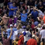 Fans try to catch St. Louis Cardinals' Paul Goldschmidt's a solo home run against the Arizona Diamondbacks during the first inning of a baseball game, Friday, Aug. 19, 2022, in Phoenix. (AP Photo/Matt York)