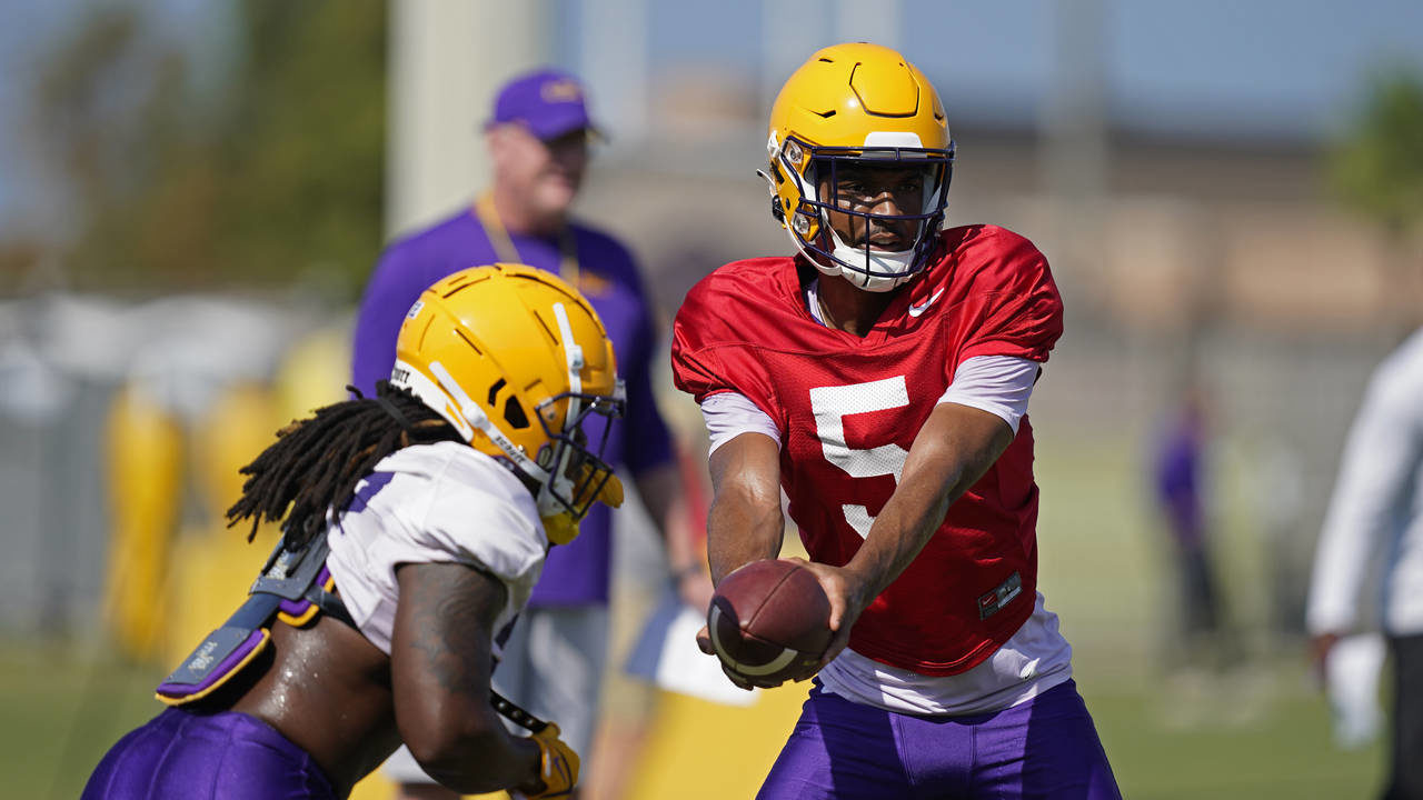 LSU quarterback Jayden Daniels (5) hands off to running back Armoni Goodwin during their NCAA colle...