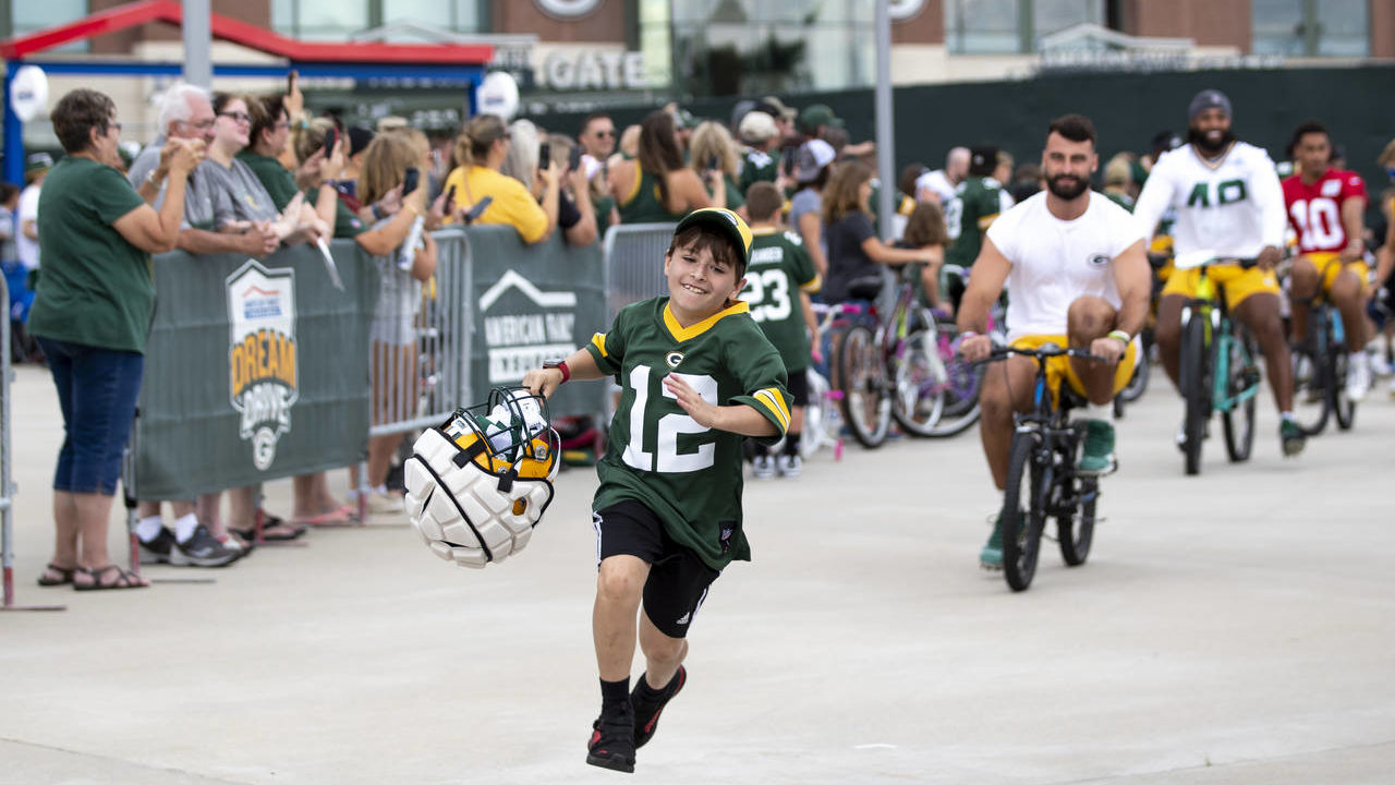 FILE - Green Bay Packers tight end Josiah Deguara, third from right, rides a young fan's bike as th...