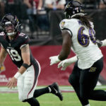 Arizona Cardinals quarterback Trace McSorley (19) looks to pass under pressure from Baltimore Ravens linebacker Steven Means (60) during the first half of an NFL preseason football game, Sunday, Aug. 21, 2022, in Glendale, Ariz. (AP Photo/Rick Scuteri)