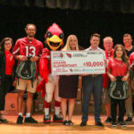 Members of the Arizona Cardinals, including WRs Antoine Wesley and Greg Dortch, along with Albertsons/Safeway representatives hold up a $10,000 check made out to Adams Elementary on Monday, Sept. 12, 2022, in Mesa. (Tyler Drake/Arizona Sports)