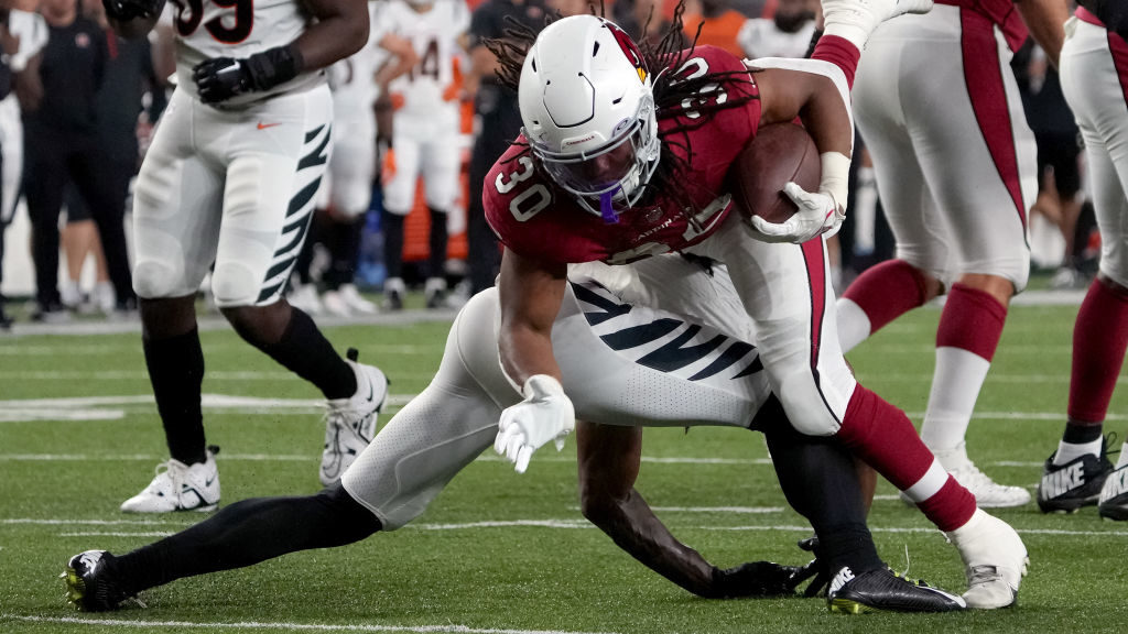 Keaontay Ingram #30 of the Arizona Cardinals runs with the ball while being tackled by Trayvon Hend...