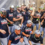 Cleveland Guardians players celebrate winning the American League Central in the locker room after defeating the Texas Rangers in a baseball game in Arlington, Texas, Sunday, Sept. 25, 2022. (AP Photo/Gareth Patterson)