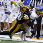 
              South Dakota State running back Isaiah Davis (22) is tackled by Iowa defensive back Kaevon Merriweather (26) during the first half of an NCAA college football game, Saturday, Sept. 3, 2022, in Iowa City, Iowa. (AP Photo/Charlie Neibergall)
            
