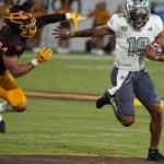 Eastern Michigan quarterback Austin Smith (19) runs away from Arizona State's Kyle Soelle (34) during the first half of an NCAA college football game Saturday, Sept. 17, 2022, in Tempe, Ariz. (AP Photo/Darryl Webb)