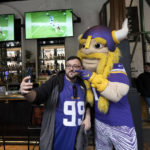 
              Viktor the mascot for the The Minnesota Vikings team poses for pictures with a supporter of the team at a fan interaction event at The Brotherhood Of Pursuits And Pastimes sports bar in Manchester, England, Wednesday, Sept. 28, 2022. A half-dozen NFL teams are aggressively targeting fans in Britain now that they have new marketing rights in the country. They’re signing commercial deals and hiring local media personalities in bids to expand their fanbases and tap international revenue. (AP Photo/Jon Super)
            