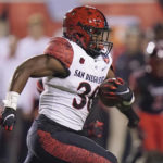 
              San Diego State running back Lucky Avinger (30) carries the ball against Utah during the first half of an NCAA college football game Saturday, Sept. 17, 2022, in Salt Lake City. (AP Photo/Rick Bowmer)
            