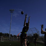 
              Aly Young, center, reaches to catch a pass as she and other Redondo Union High School girls try out for a flag football team on Thursday, Sept. 1, 2022, in Redondo Beach, Calif. Southern California high school sports officials will meet on Thursday, Sept. 29, to consider making girls flag football an official high school sport. This comes amid growth in the sport at the collegiate level and a push by the NFL to increase interest. (AP Photo/Ashley Landis)
            