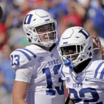 Duke quarterback Riley Leonard (13) celebrates with Duke running back Jaylen Coleman (22) after Coleman scored a touchdown during the first half of an NCAA college football game against Kansas Saturday, Sept. 24, 2022, in Lawrence, Kan. (AP Photo/Charlie Riedel)