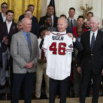 
              President Joe Biden holds up a jersey during an event celebrating the 2021 World Series champion Atlanta Braves, in the East Room of the White House, Monday, Sept. 26, 2022, in Washington. From left, Braves President of Baseball Operations Alex Anthopoulos, manager Brian Snitker, Biden, and Braves President and CEO Terry McGuirk. (AP Photo/Evan Vucci)
            