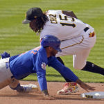 Chicago Cubs' Nelson Velazquez is tagged out attempting to steal second by Pittsburgh Pirates shortstop Oneil Cruz (15) during the seventh inning of a baseball game in Pittsburgh, Sunday, Sept. 25, 2022. (AP Photo/Gene J. Puskar)