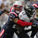 New England Patriots safety Adrian Phillips, left, tackles Baltimore Ravens running back Justice Hill, right, in the first half of an NFL football game, Sunday, Sept. 25, 2022, in Foxborough, Mass. (AP Photo/Michael Dwyer)