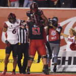 Utah wide receiver Devaughn Vele, center, rear, celebrates with teammate Keaton Bills (51) after scoring against San Diego State safety CJ Baskerville (6) during the first half of an NCAA college football game Saturday, Sept. 17, 2022, in Salt Lake City. (AP Photo/Rick Bowmer)