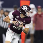 
              Texas A&M quarterback Max Johnson (14) looks for an open receiver during the first half of the team's NCAA college football game against Arkansas on Saturday, Sept. 24, 2022, in Arlington, Texas. (AP Photo/Brandon Wade)
            