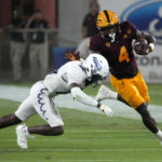 Arizona State running back Daniyel Ngata (4) fends off Northern Arizona defensive back Colby Humphrey during the first half of an NCAA college football game Thursday, Sept. 1, 2022, in Tempe, Ariz. (AP Photo/Rick Scuteri)