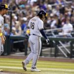 Milwaukee Brewers' Keston Hiura (18) walks back to the dugout after being picked off at first base as Brewers first base coach Quintin Berry, left, looks on during the second inning of a baseball game against the Arizona Diamondbacks, Friday, Sept. 2, 2022, in Phoenix. (AP Photo/Ross D. Franklin)
