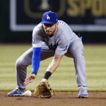 Los Angeles Dodgers shortstop Trea Turner fields a grounder hit by Arizona Diamondbacks' Geraldo Perdomo, who was out at first during the sixth inning of a baseball game in Phoenix, Tuesday, Sept. 13, 2022. (AP Photo/Ross D. Franklin)