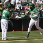 
              Oakland Athletics' Seth Brown, right, is congratulated by third base coach Darren Bush (51) as he rounds the bases after hitting a solo home run during the third inning of a baseball game against the New York Mets in Oakland, Calif., Saturday, Sept. 24, 2022. (AP Photo/Tony Avelar)
            