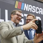 
              Dale Earnhardt Jr., left, laughs with Speedway Motorsports President and CEO Marcus Smith as they record a video after a press conference announcing that the NASCAR All-Star Race will be held at North Wilkesboro Speedway in May 2023, on the steps of the N.C. Museum of History in Raleigh, N.C., Thursday, Sept. 8, 2022. (Ethan Hyman/The News & Observer via AP)
            