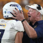 Northern Arizona coach Chris Ball talks to defensive back Morgan Vest (7) during the second half of the team's NCAA college football game against Arizona State, Thursday, Sept. 1, 2022, in Tempe, Ariz. (AP Photo/Rick Scuteri)