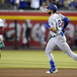 Los Angeles Dodgers' Joey Gallo, right, runs the bases after hitting a two-run home run, past Arizona Diamondbacks second baseman Ketel Marte during the second inning of a baseball game in Phoenix, Tuesday, Sept. 13, 2022. (AP Photo/Ross D. Franklin)