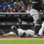 Minnesota Twins' Gio Urshela, left, scores past Chicago White Sox catcher Yasmani Grandal during the fourth inning of a baseball game Wednesday, Sept. 28, 2022, in Minneapolis. (AP Photo/Craig Lassig)