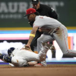 Milwaukee Brewers' Hunter Renfroe, left, slides in safely at second base past a tag by Cincinnati Reds' Jose Barrero, right, during the eighth inning of a baseball game Saturday, Sept. 10, 2022, in Milwaukee. (AP Photo/Aaron Gash)