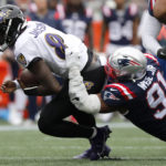 Baltimore Ravens quarterback Lamar Jackson (8) is brought down by New England Patriots defensive end Deatrich Wise Jr. (91) in the first half of an NFL football game, Sunday, Sept. 25, 2022, in Foxborough, Mass. (AP Photo/Paul Connors)
