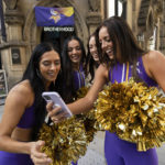 
              Cheerleaders for the The Minnesota Vikings check the footage after recording a TikTok video at a fan interaction event at The Brotherhood Of Pursuits And Pastimes sports bar in Manchester, England, Wednesday, Sept. 28, 2022. A half-dozen NFL teams are aggressively targeting fans in Britain now that they have new marketing rights in the country. They’re signing commercial deals and hiring local media personalities in bids to expand their fanbases and tap international revenue. (AP Photo/Jon Super)
            