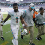 
              Miami Dolphins quarterback Tua Tagovailoa (1) is assisted off the field after he was injured during the first half of an NFL football game against the Buffalo Bills, Sunday, Sept. 25, 2022, in Miami Gardens, Fla. (AP Photo/Wilfredo Lee )
            