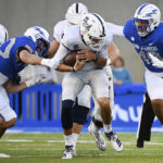 Air Force linebacker Alec Mock, second from left, and defensive end Jayden Thiergood, right, bring down Nevada quarterback Nate Cox, center, after a short gain during the first half of an NCAA college football game Friday, Sept. 23, 2022, in Air Force Academy, Colo. (Christian Murdock/The Gazette via AP)