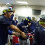 Los Angeles Dodgers celebrate in the locker room after the team's 4-0 win in a baseball game win against the Arizona Diamondbacks in Phoenix, Tuesday, Sept. 13, 2022. The Dodgers clinched the National League West. (AP Photo/Ross D. Franklin)