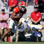 
              Georgia running back Kenny McIntosh (6) slips past Kent State safety Nico Bolden (24) in the first half of an NCAA college football game Saturday, Sept. 24, 2022, in Athens, Ga. (AP Photo/John Bazemore)
            