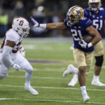 Washington Wayne Taulapapa looks to fend off Stanford defensive back Alaka'i Gilman during the first half of an NCAA college football game Saturday, Sept. 24, 2022, in Seattle. (AP Photo/Stephen Brashear)