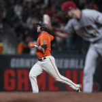 San Francisco Giants' Austin Wynns, left, runs the bases after hitting a solo home run off Arizona Diamondbacks relief pitcher Sean Poppen, foreground, during the sixth inning of a baseball game in San Francisco, Friday, Sept. 30, 2022. (AP Photo/Godofredo A. Vásquez)