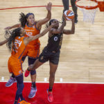 Las Vegas Aces guard Jackie Young (0) gets inside of Connecticut Sun center Brionna Jones (42) and forward DeWanna Bonner (24) for a basket during the first half in Game 1 of a WNBA basketball final playoff series Sunday, Sept. 11, 2022, in Las Vegas. (AP Photo/L.E. Baskow)