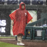 
              A security guard stands during a rain delay in the fifth inning of a baseball game between the Philadelphia Phillies and the Atlanta Braves, Sunday, Sept. 25, 2022, in Philadelphia. (AP Photo/Laurence Kesterson)
            