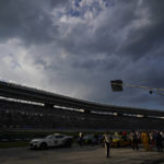 With clouds threatening lightning, a NASCAR Cup Series auto race field sits under a red flag delay at Texas Motor Speedway in Fort Worth, Texas, Sunday, Sept. 25, 2022. (AP Photo/LM Otero)
