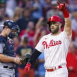 
              Philadelphia Phillies' Bryce Harper, right, reacts to his two-run home run, next to Washington Nationals catcher Riley Adams during the third inning of a baseball game Saturday, Sept. 10, 2022, in Philadelphia. (AP Photo/Chris Szagola)
            