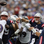 New England Patriots quarterback Mac Jones (10) passes under pressure from Baltimore Ravens linebacker Odafe Oweh (99) in the first half of an NFL football game, Sunday, Sept. 25, 2022, in Foxborough, Mass. (AP Photo/Michael Dwyer)