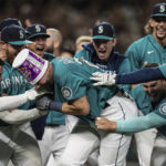 
              Seattle Mariners including Jesse Winker, left; Ty France, third from right; Logan Gilbert, second from right; and Adam Frazier, right celebrate a home run by Cal Raleigh in ninth inning of a baseball game against the Oakland Athletics, Friday, Sept. 30, 2022, in Seattle. The Mariners won 2-1 to clinch a spot in the playoffs. (AP Photo/Stephen Brashear)
            