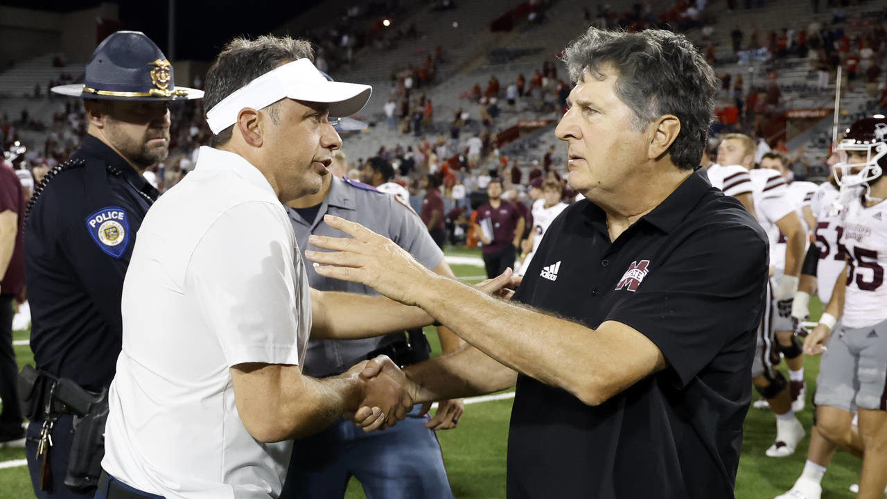 Arizona head coach Jedd Fisch, left, shakes hands with Mississippi State head coach Mike Leach afte...