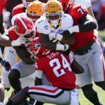 
              Kent State running back Marquez Cooper (1), center, is stopped by Georgia defenders Malaki Starks (24), Nazir Stackhouse (78), and Javon Bullard (22) in the first half of an NCAA college football game Saturday, Sept. 24, 2022, in Athens, Ga. (AP Photo/John Bazemore)
            