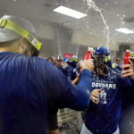 Los Angeles Dodgers celebrate in the locker room after a 4-0 win in a baseball game against the Arizona Diamondbacks in Phoenix, Tuesday, Sept. 13, 2022. The Dodgers clinched the National League West. (AP Photo/Ross D. Franklin)