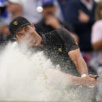 
              Adam Scott, of Australia, hits from a bunker on the 15th hole during their singles match at the Presidents Cup golf tournament at the Quail Hollow Club, Sunday, Sept. 25, 2022, in Charlotte, N.C. (AP Photo/Julio Cortez)
            