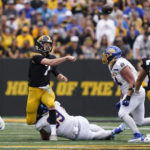 
              Iowa quarterback Spencer Petras (7) throws a pass as he is tackled by South Dakota State defensive tackle Caleb Sanders (99) during the first half of an NCAA college football game, Saturday, Sept. 3, 2022, in Iowa City, Iowa. (AP Photo/Charlie Neibergall)
            