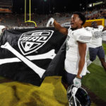 Eastern Michigan's Dexter Manior (91), left, Korey Hernandez (5), middle, and Melvin Swindle II, (99), right, wave the Mid-America Conference flag after their 30-21 win over Arizona State's at the end of an NCAA college football game Saturday, Sept. 17, 2022, in Tempe, Ariz. (AP Photo/Darryl Webb)