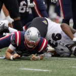 
              New England Patriots quarterback Mac Jones, left, is brought down by Baltimore Ravens defensive tackle Calais Campbell, right, in the second half of an NFL football game, Sunday, Sept. 25, 2022, in Foxborough, Mass. Jones limped to the sideline following the play. (AP Photo/Paul Connors)
            